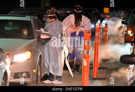 Wilkes-Barre, Pennsylvania, USA. 6th Jan, 2022. Healthcare workers wearing Personal Protective Equipment (PPE) gears collect nasal swab samples from people at a drive thru test site.With the new Omicron variant Covid-19 surge, testing sites are seeing long lines for testing. Employees from AMI Expeditionary Healthcare are seen in Pennsylvania giving Covid-19 tests. The group has been moving from hotel to hotel and working 12 hour days, 4-5 days a week to test community members for Covid-19. (Credit Image: © Aimee Dilger/SOPA Images via ZUMA Press Wire) Stock Photo