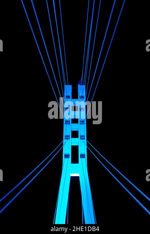 Low-angle closeup view of illuminated pylon of the Bridge of Lovers on the background of night sky, Tyumen, Russia Stock Photo