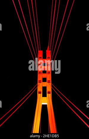 Low-angle closeup view of illuminated pylon of the Bridge of Lovers on the background of night sky, Tyumen, Russia Stock Photo