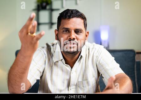 Fat man confidently explaining or talking by looking at camera on video call - concept of online video conference, meeting and webinar. Stock Photo