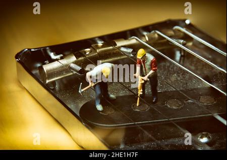 Miniature Workers Fixing An Electric Guitar Pickup Stock Photo
