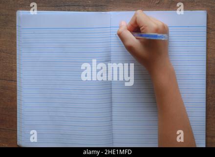 Boy's hand writing on notebook, education concept Stock Photo