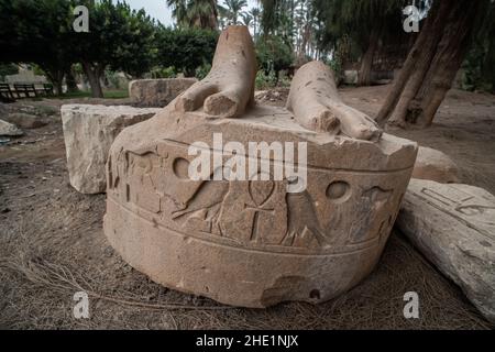 The broken base of a statue with 2 falcons and an ankh as well as other hieroglyphs inscribed on it in Memphis, Egypt. Stock Photo