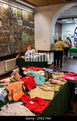 UK, Wales, Pembrokeshire, Pembroke, Main Street, Town Hall interior, craft fair in progress, knitted item stall Stock Photo