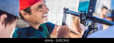 Professional steadicam operator uses a 3-axis camera stabilizer system on a commercial production set BANNER, LONG FORMAT Stock Photo