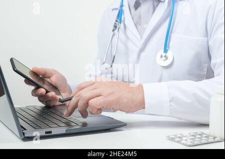 Doctor using laptop for online consultation. Doctor hand typing on laptop keyboard. Physician in hospital office working on laptop. doctor working and Stock Photo