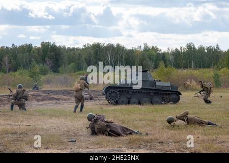 Battle of Soviet and German soldiers. Attack of Soviet soldiers and a T25 tank. Reconstruction of the battle of World War II. Russia, Chelyabinsk regi Stock Photo