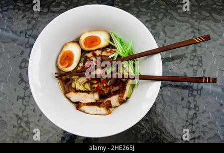 Japanese Ramen noodle soup with marinated eggs, cooked seaweed, chashu pork and broth Stock Photo