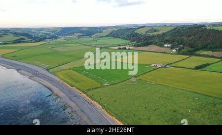 Aerial image of the beach, sea, fields and Llanrhystud Village.  View incudes hills in the background on cloudy day Stock Photo