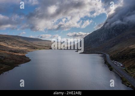 Aerial view of flying drone Epic early Autumn Fall landscape image of view along Ogwen vslley in Snowdonia National Park with dramatic sky and mountai Stock Photo