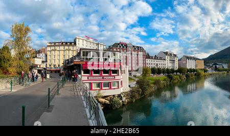 Lourdes, France - October 26, 2021: Hotels and restaurants in Lourdes on the riverside of river Ousse. Lourdes is a pilgrimage place known for apparit
