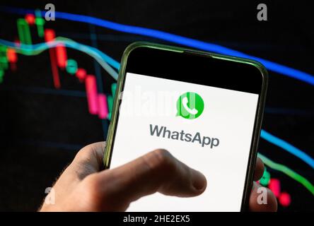 China. 09th Dec, 2021. In this photo illustration the encrypted instant messaging application owned by Meta Platforms and formerly known as Facebook, WhatsApp, logo seen displayed on a smartphone with an economic stock exchange index graph in the background. (Photo by Budrul Chukrut/SOPA Images/Sipa USA) Credit: Sipa USA/Ģ����ý Live News Stock Photo