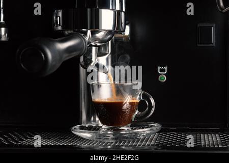 Close up view of modern espresso coffee machine making coffee in a cup. Stock Photo