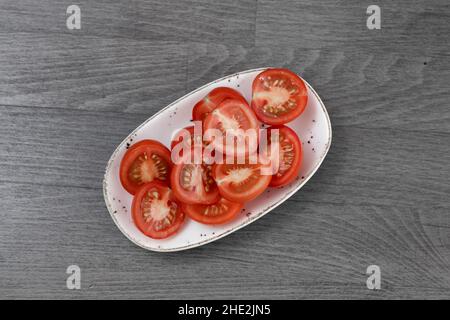 sliced tomatoes on wooden table Stock Photo