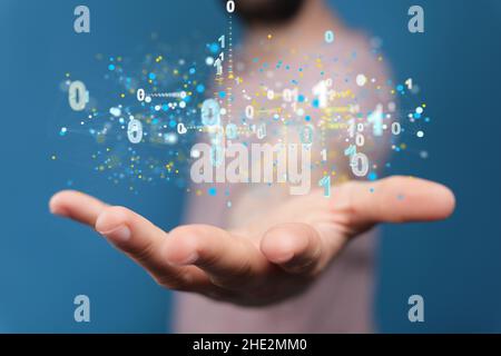 Businessman holding a floating digital render of binary code Stock Photo