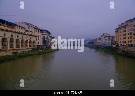 Florence, Italy: View from the Florence Ponte Vecchio on a rainy day on River Arno, canal, and colorful buildings on the banksides Stock Photo
