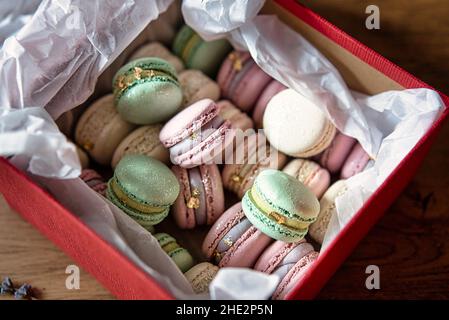 French macaroon cake. Macaroons in box with dried flowers on wooden background flat lay. Stock Photo