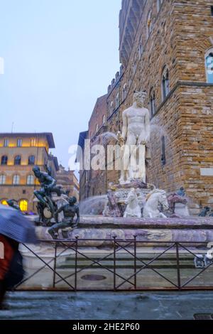 Fountain of Neptune on the Piazza, square della Signoria across Palazzo Vecchio and other buildings in Florence, Italy Stock Photo