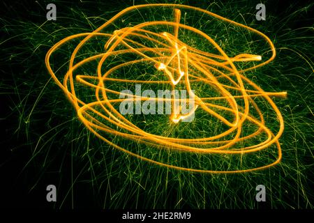Sparks of holiday light fly on a black background. Drawing with light on a long frame Stock Photo