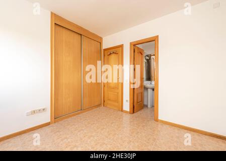 room with oak carpentry, built-in wardrobe with sliding doors and en suite bathroom Stock Photo