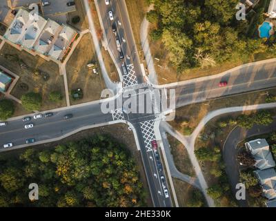 Top down aerial view of cars driving through intersection at sunset in residential neighbourhood, Montreal, Quebec, Canada, North America. Stock Photo