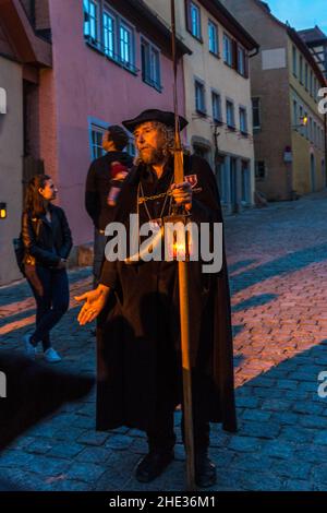 vertical-shot-of-the-night-watchman-tour-in-rothenburg-germany-stock