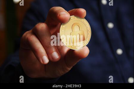 Cyber security, protection, cryptocurrency and secure payment with padlock symbol golden coin in hand abstract concept. Stock Photo
