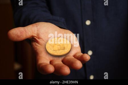 Cyber security, protection, cryptocurrency and secure payment with padlock symbol golden coin in hand abstract concept. Stock Photo