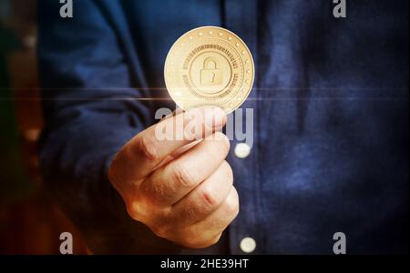 Cyber security, protection, cryptocurrency and secure payment with padlock symbol golden coin in hand abstract concept. Stock Photo