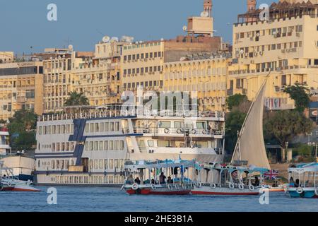 Boats docked along the edge of the Nile river in Aswan city in Southern Egypt. Stock Photo