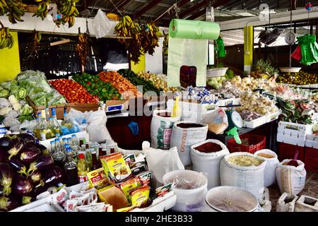 A selection of beans, spices, fruits, and vegetables are on display at a stand in the Belize City Market. Stock Photo