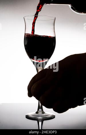 Serving a beautiful glass with red wine. White background, Glass cup. Elegance, good taste, style concept. Stock Photo