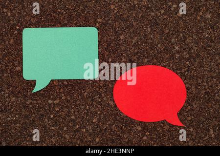 Two speech bubbles laying on a cork board. Close up. Stock Photo