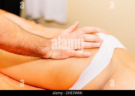 An attractive latin american woman lying down on a massage bed at spa Stock Photo