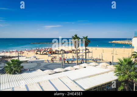 Tel-Aviv Beach on Mediterranean sea. Enjoy the sun taking a walk on the promenade or along the beach. Mediterranean breeze and tall buildings. Stock Photo