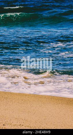 Soft ocean waves with foam on a sandy beach Stock Photo