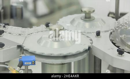 Ampoule filling and sealing machine equipment in pharmaceutical industry. Pharmaceutics. Pharmaceutical worker operates tablet blister packaging machi Stock Photo