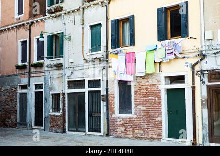View of drying laundry outside apartment window in an old building in Venice, Italy Stock Photo