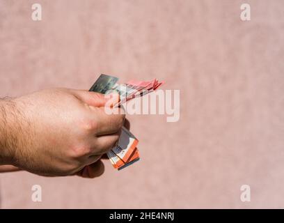 Hand holding showing euro money and giving or receiving money like tips, salary. 5 and 10 EURO banknotes EUR currency isolated. Concept of rich busine Stock Photo