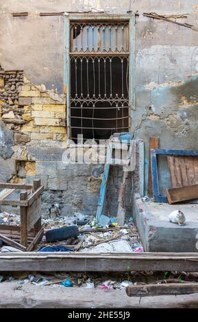 Day shot of old abandoned stone bricks wall with one grunge broken wrought iron window Stock Photo