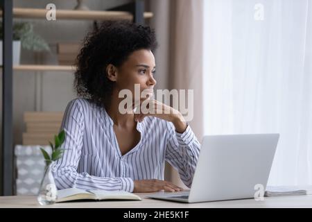 Thoughtful young successful african businesswoman looking in distance. Stock Photo