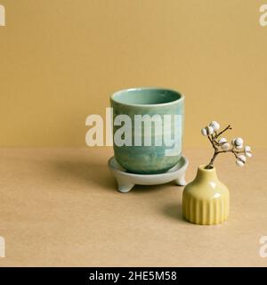 Ceramic tea cup with dry plant on brown table background Stock Photo