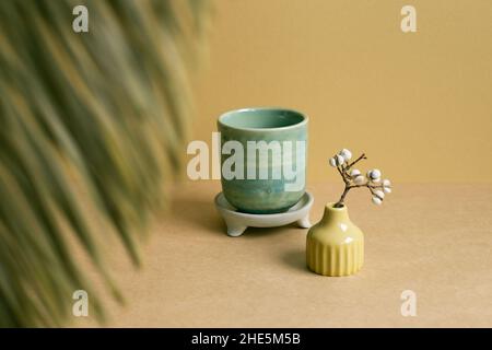 Ceramic tea cup with dry plant on brown table background Stock Photo