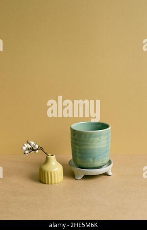 Ceramic tea cup with dry plant on brown table background Stock Photo