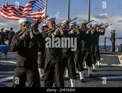 Sailors fire the first of three volleys to honor the deceased during a burial at sea ceremony aboard the Arleigh Burke-class guided-missile destroyer USS Mahan. (30986424160). Stock Photo