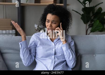 Unhappy millennial african woman holding unpleasant conversation. Stock Photo