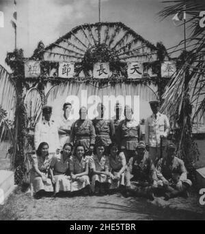 Pacific War, 1941-1945. Sailors and civil officers of the Imperial Japanese Navy and Indonesian locals gather to celebrate the birthday of Emperor Hirohito in Japanese-occupied Celebes, Dutch East Indies, April 29th, circa 1942. Stock Photo