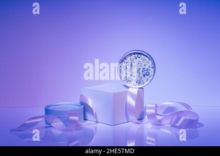 Podium, assorted gift boxes with satin ribbon on purple background Stock Photo