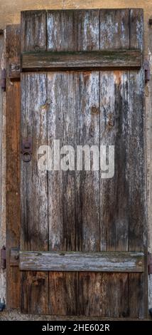 Vertical shot of a rusty old vintage wooden door with white grunge rust Stock Photo