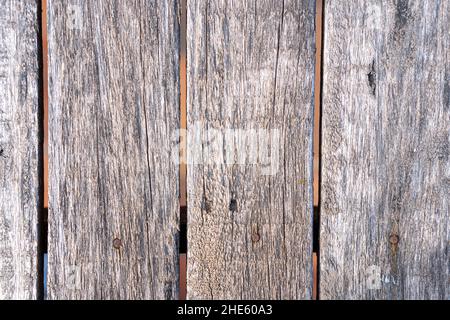 Close-up shot of an old weathered grungy wooden fence under the sunlight texture Stock Photo